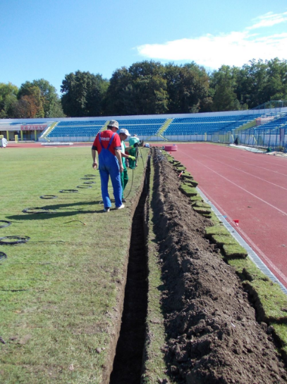 Cablurile pentru instalația de încălzire a gazonului sunt introduse pe lângă tuburile de drenaj 