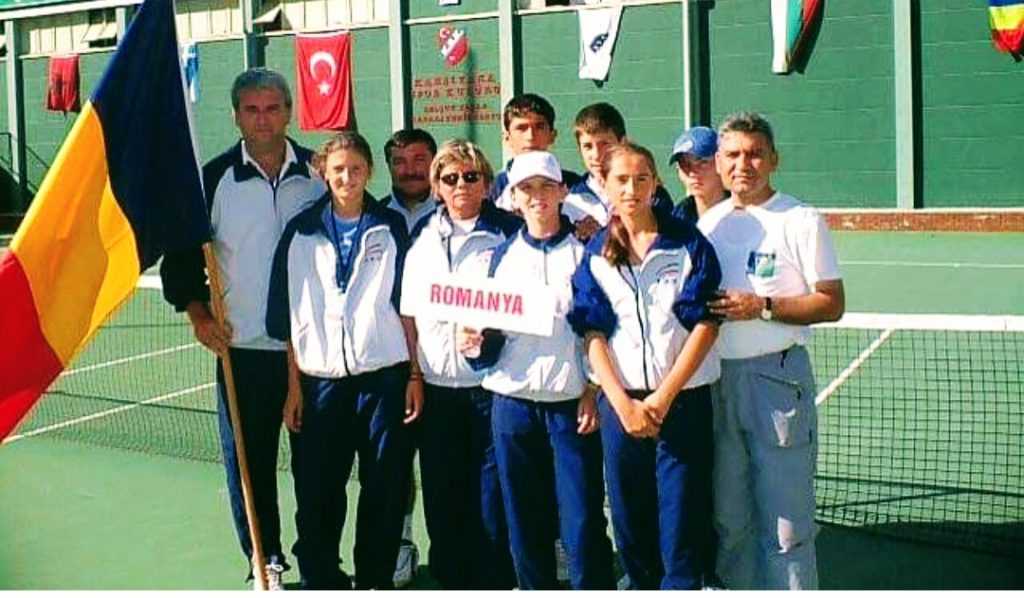 Liviu Ursuleanu, stânga, a fost antrenorul loturilor de juniori la Balcaniada din 2004. În echipa de fete jucau Simona Halep, cea care ține pancarta pe care scrie Romanya, Irina Begu și Cadanțu. În fotografie mai sunt regretata Florența Mihai, fostă antrenoare federală, Curcă Costel, antrenor, tatăl Simonei Halep, dreapta și juniorii Marius Cîrstea, Adrian Belei și Ale Vodislav