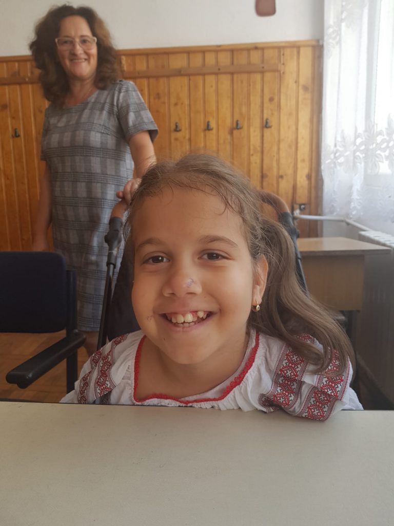 Lecția de voință a unui copil. Delia învață să scrie ajutându-se de umăr și de obraz