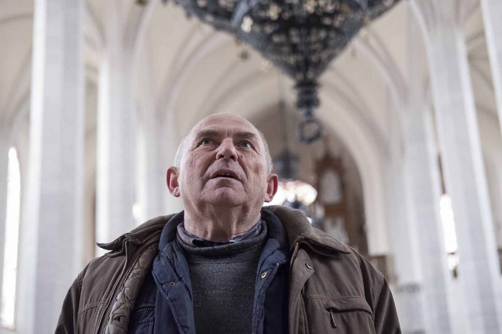 Andras bacsi cantă un imn bisericesc ce răsună puternic în biserica goală.