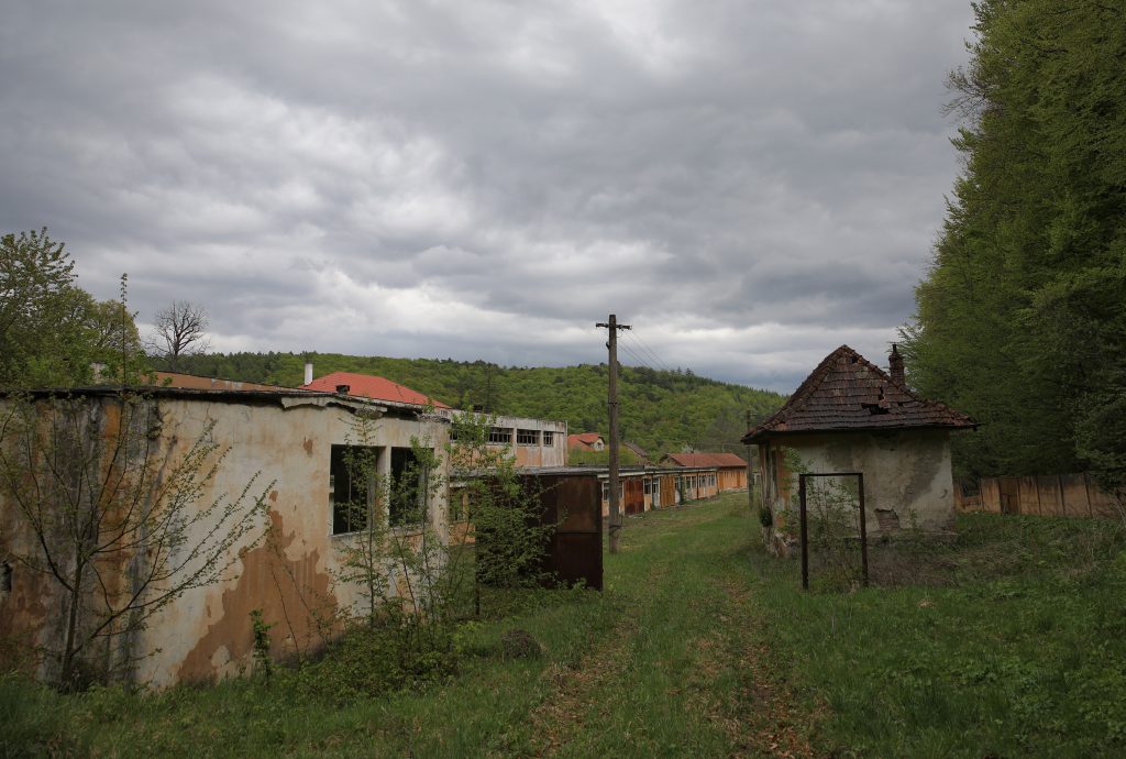 Imagine cu ruinele fostei fabrici de conserve și clădirile abandonate de la intrarea în mină