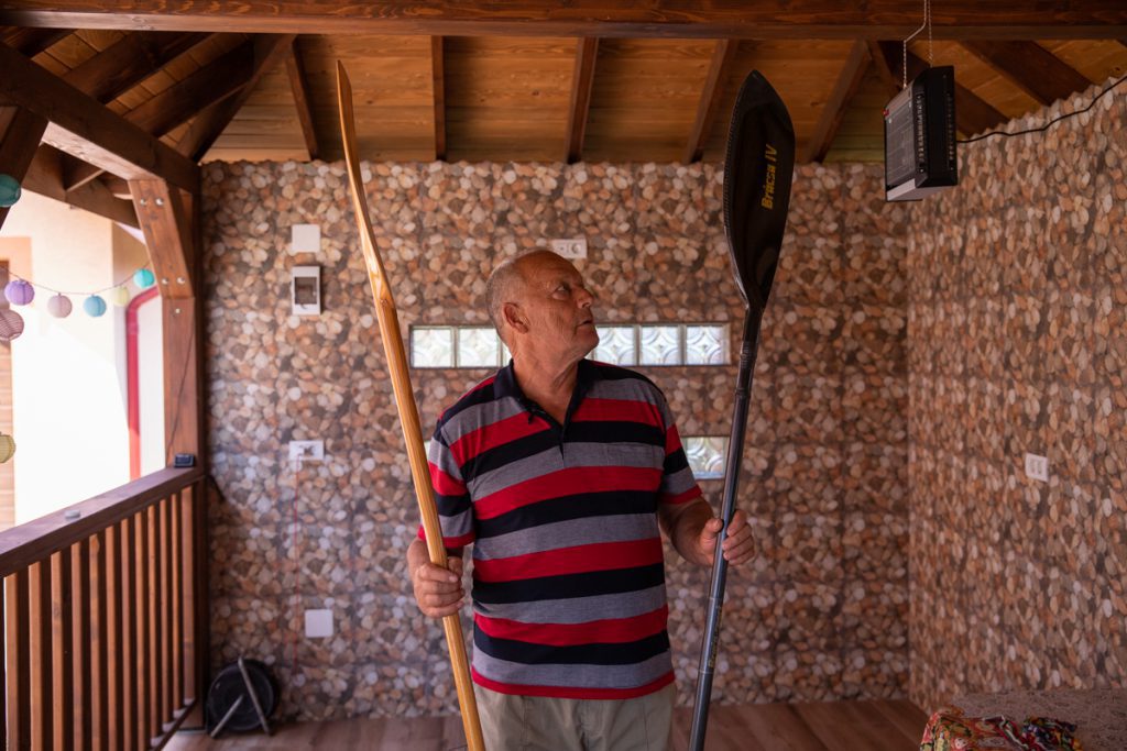 Vasile Dîba, în foișorul casei din Jurilovca, alături de două obiecte dragi. Foto: Vlad Chirea