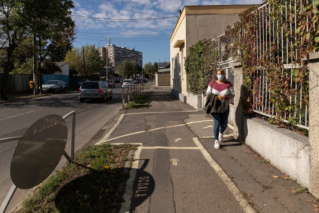 O femeie purtând mască de protecție trece prin fața unei școli din Sectorul 5. Foto: Vlad Chirea