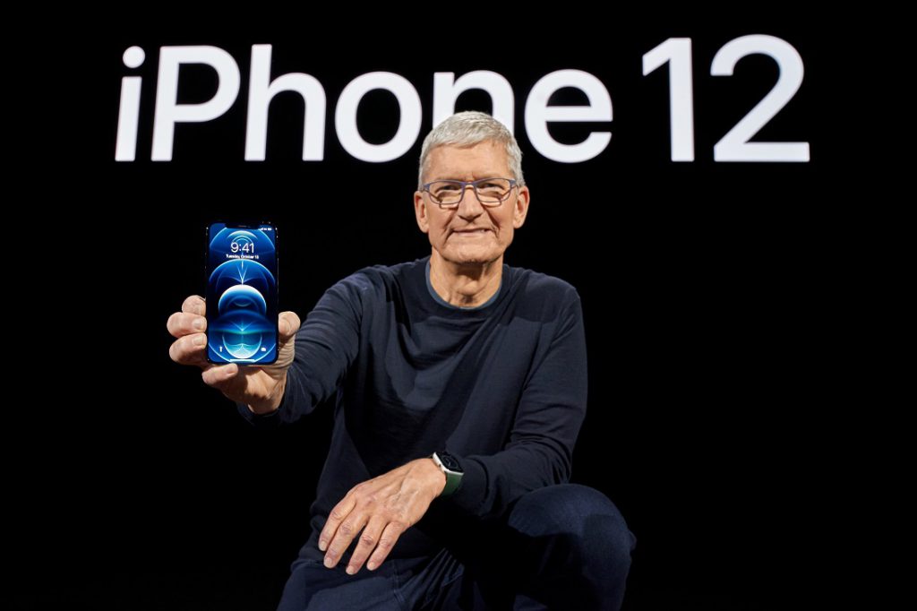 The late launch of a new iPhone shook Apple's $ 100 billion value.  Tim Cook, Apple boss, with iPhone 12 Pro in hand and phone name in background