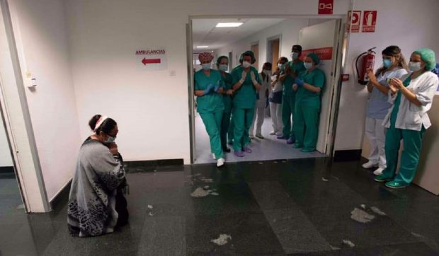 Fotografia anului în Navarra, Spania. Mamă româncă, în genunchi în fața medicilor care i-au salvat fiul bolnav de COVID