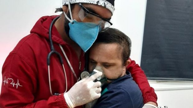 Imaginea umanității în Brazilia devastată de coronavirus. Un asistent medical îmbrățișează un bărbat cu sindrom Down care are COVID