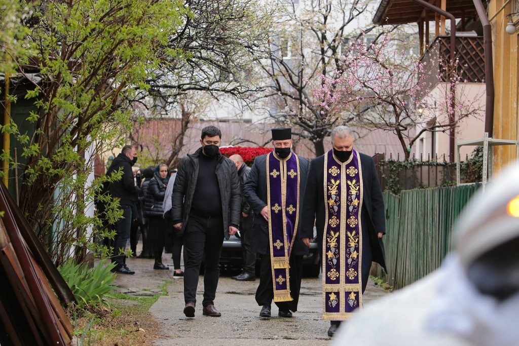 GALERIE FOTO | Nelu Ploieșteanu a fost înmormântat astăzi. Sicriul artistului, purtat pe umeri de oameni în combinezoane albe