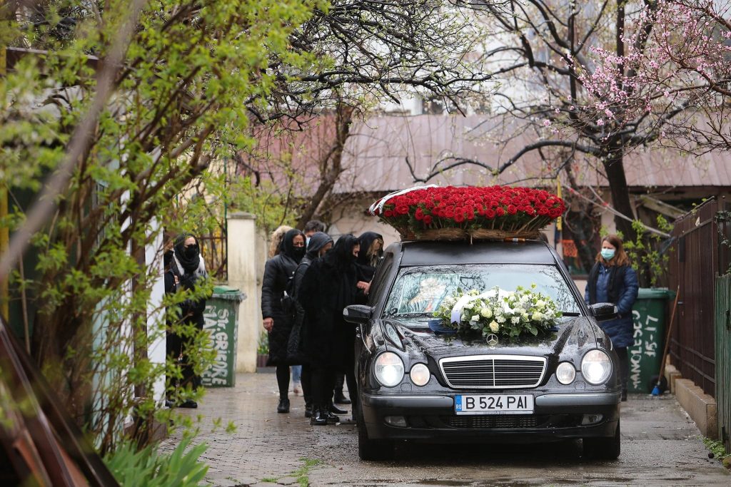 GALERIE FOTO | Nelu Ploieșteanu a fost înmormântat astăzi. Sicriul artistului, purtat pe umeri de oameni în combinezoane albe