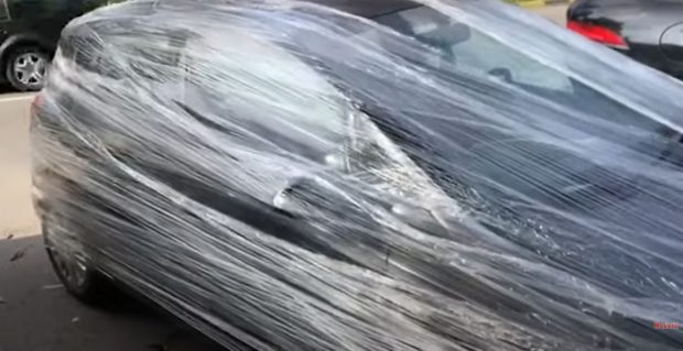 Mașină acoperită cu folie pe o stradă în Suceava, din cauza felului în care a fost parcată