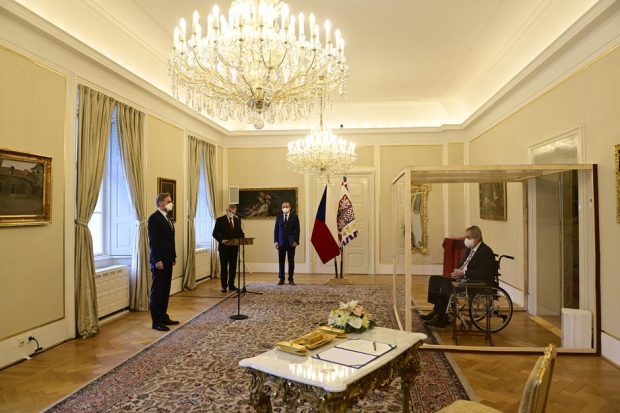 IMAGINEA ZILEI: Președintele Cehiei, bolnav de COVID, a stat într-o cabină de plexiglas la depunerea jurământului de către noul premier