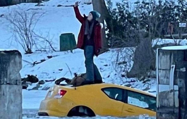 VIDEO | O șoferiță își făcea zâmbitoare selfi-uri pe mașina care se scufunda, după ce a condus cu viteză pe un râu înghețat