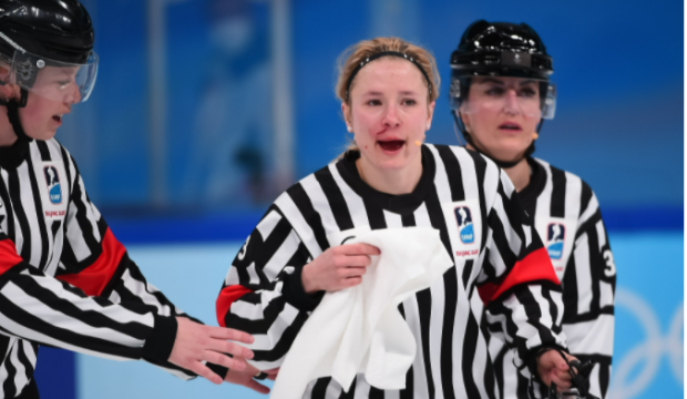 Arbitră plină de sânge, după ce a fost lovită accidental cu crosa, în timpul meciului de hochei Canada – SUA, din turneul olimpic feminin