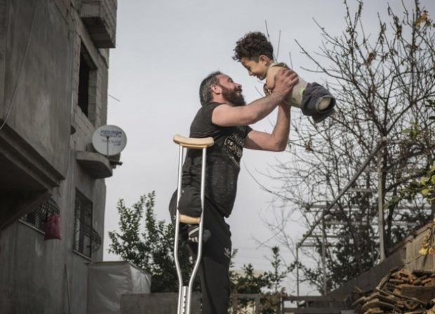 Puterea unei fotografii: cum a schimbat viața unui tată sirian schilodit într-un atac cu bombă și a fiului său născut infirm