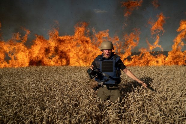 Un fotojurnalist ucrainean, surprins în timp ce fuge din calea flăcărilor care au cuprins un lan de grâu bombardat de ruși