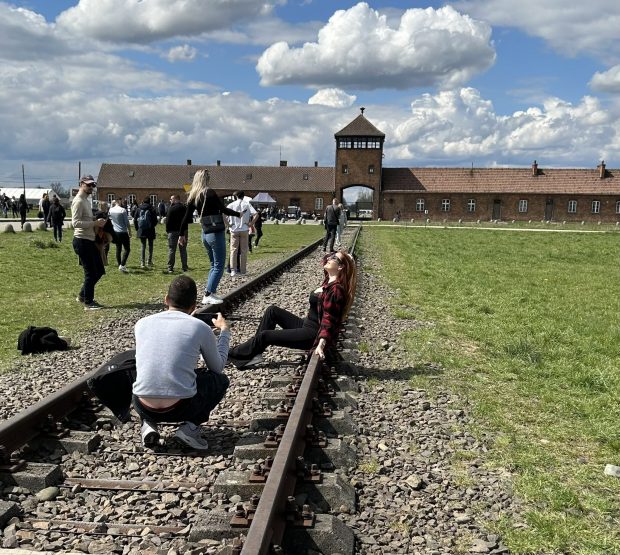O tânără care pozează lasciv pe șinele de tren care duc în fostul lagăr nazist Auschwitz a stârnit indignare pe internet. „Nu întinați memoria lor”