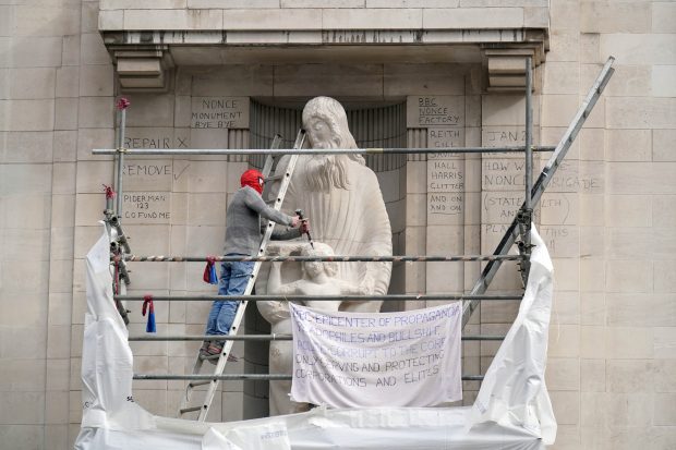 Un bărbat s-a urcat pe schelele din fața sediului BBC și a lovit cu dalta și ciocanul o statuie controversată | VIDEO