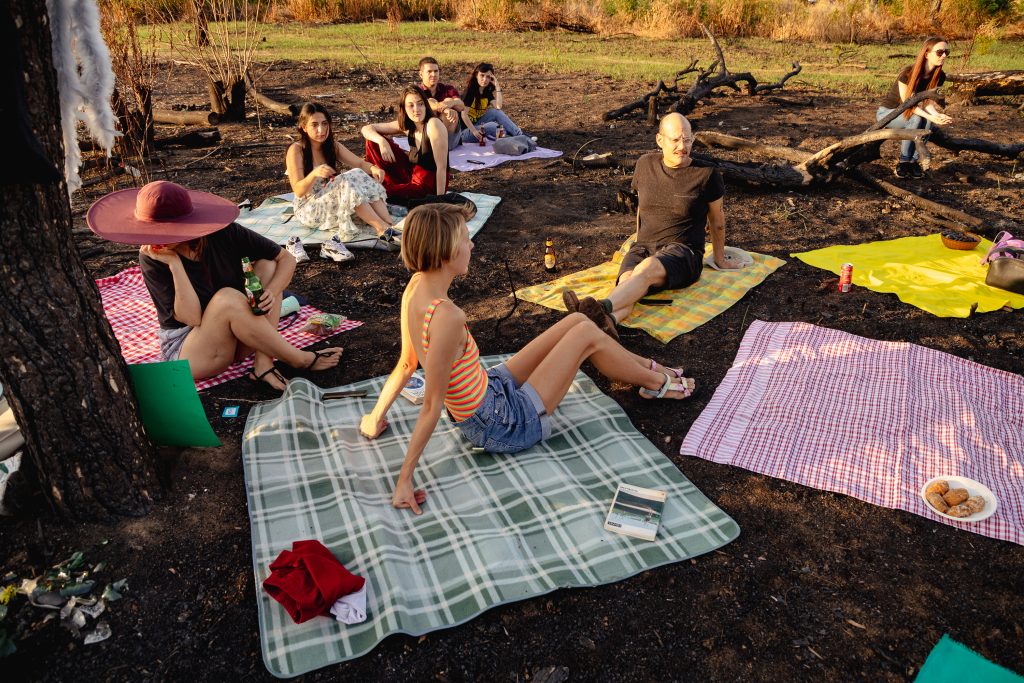 asezati pe paturi colorate oamenii au facut picnic pe pamantul ars