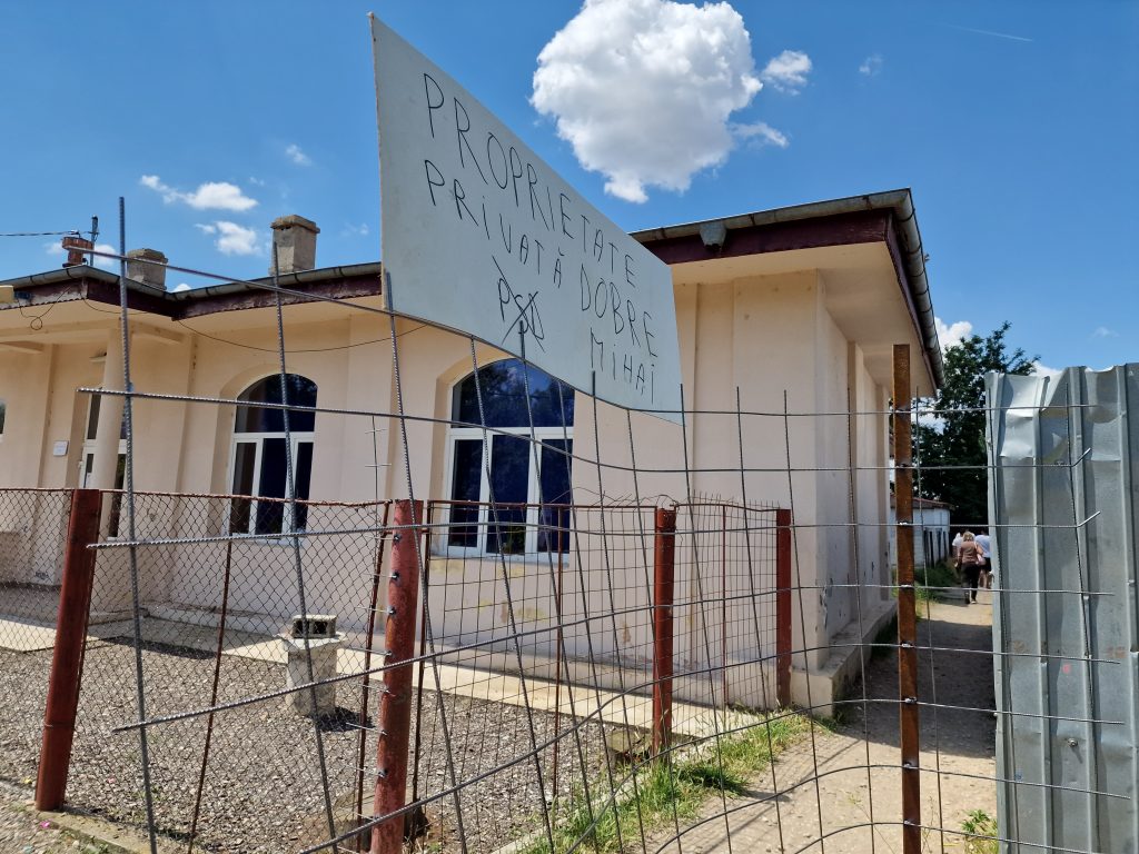 REPORTAJ Lacrimogene de campanie în Mihăilești, Giurgiu: polițiști înarmați și jandarmi au venit să oprească un protest față de primar 8 pancarta protest pusa pe grilajul care a blocat ulita 1