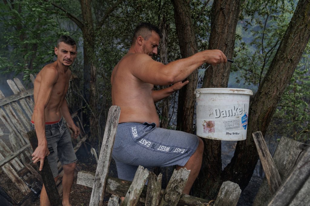 11 doi localnici trec gardul cu galeti cu apa sa i ajute pe pompieri