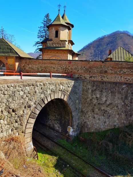 VIDEO. Imagini cu singura mănăstire din lume pe sub care trece trenul, pe malul Oltului