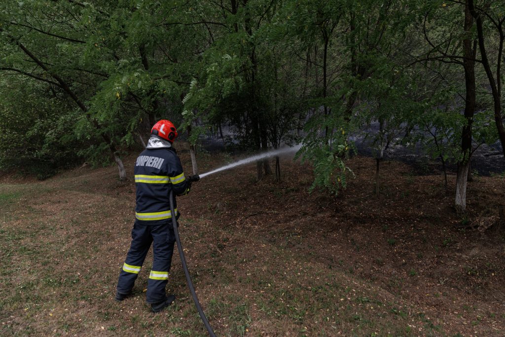 20 un pompier arunca apa pentru a oprit focul mocnit