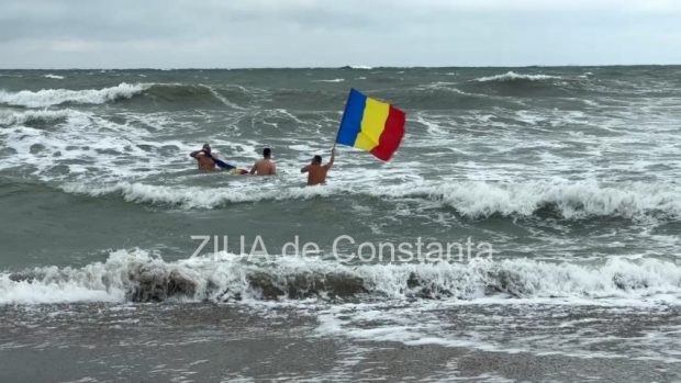 Trei constănțeni dotați cu steaguri tricolore au înotat în mare, de Ziua Națională | VIDEO