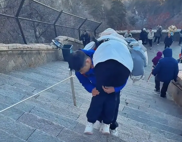Un ghid cară în spate turiștii obosiți pe munte, în China. Cât câștigă