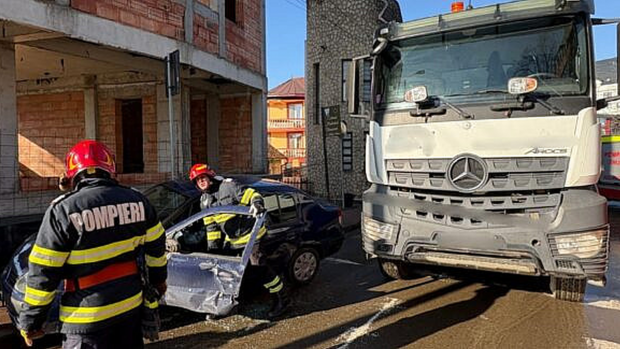Momentul în care o basculantă agață un Logan și pleacă cu el. Șoferița autoturismului a trebuit să fie descarcerată | VIDEO