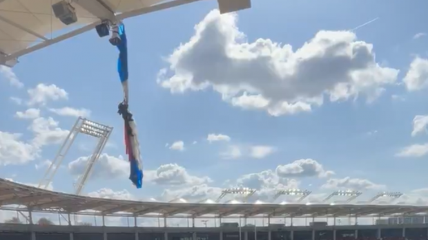 Parașutist prăbușit pe acoperișul stadionului se agață disperat în așteptarea salvatorilor