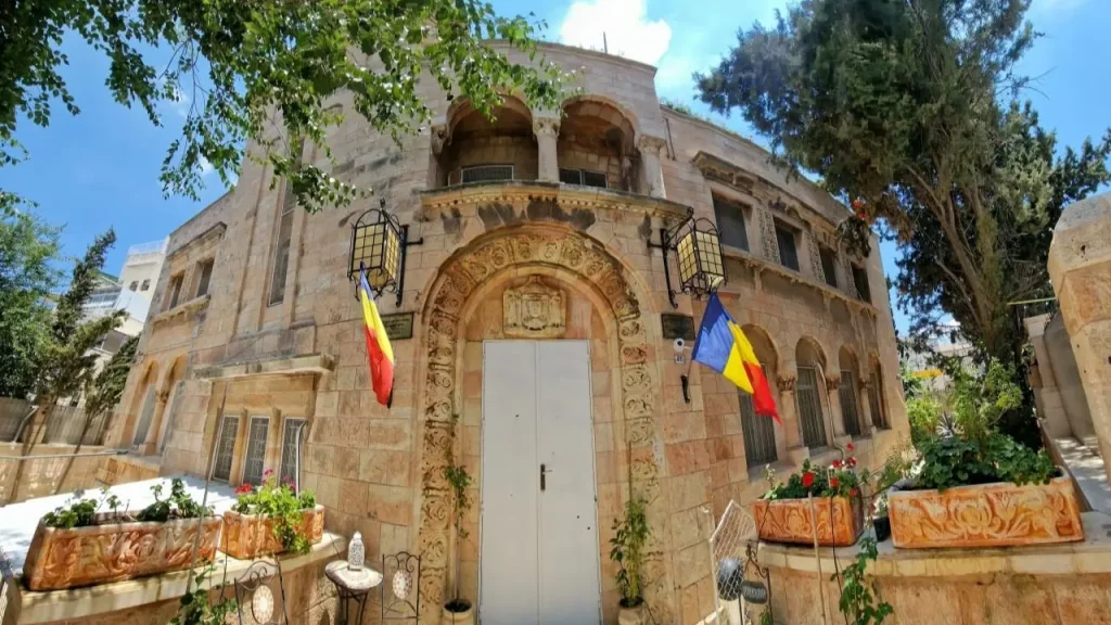 Biserica Ortodoxă Română din Ierusalim, două steaguri ale României încadrează ușa Bisericii