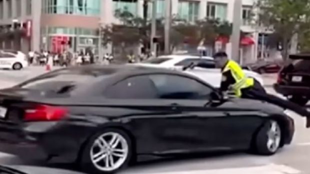 Momentul în care un polițist împușcă un șofer prin parbriz, după ce a fost luat pe capota mașinii, la Miami | VIDEO