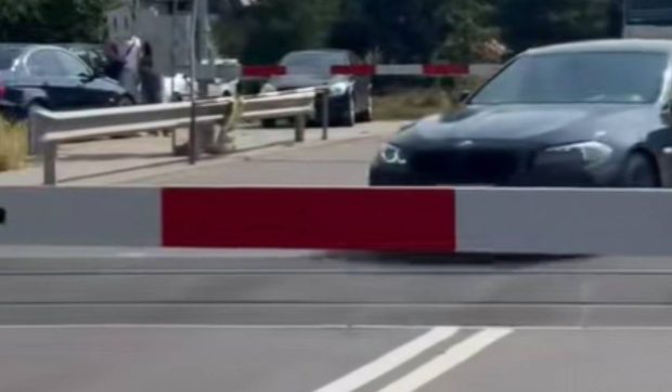 Un șofer de BMW a fost prea grăbit să aștepte să treacă trenul, așa că a ignorat complet bariera coborâtă | VIDEO