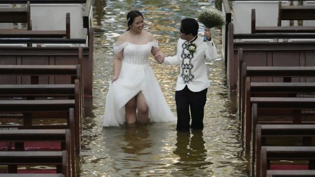 Dragoste pe timp de potop: un cuplu filipinez s-a căsătorit într-o biserică complet inundată