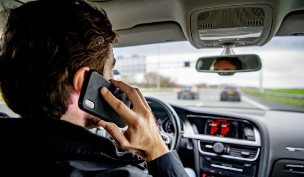 Zeci de mii de șoferi amendați cu 430 de euro pentru că au folosit telefonul la volan