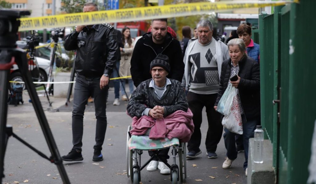 Bărbat pe scaun cu rotile în fața liceului după explozie