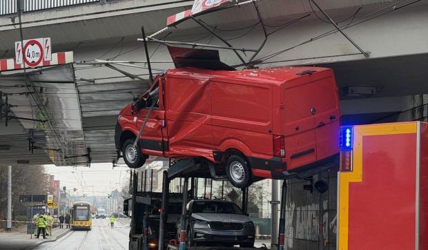 O dubă a rămas agățată de liniile de tramvai, înainte de trecerea pe sub un pod dintr-un oraș german