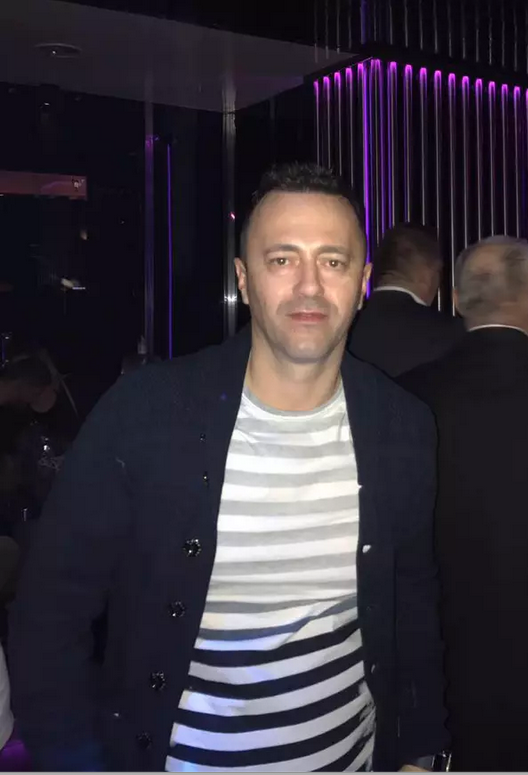 Un barbat in tricou cu dungi si un sacoi negru