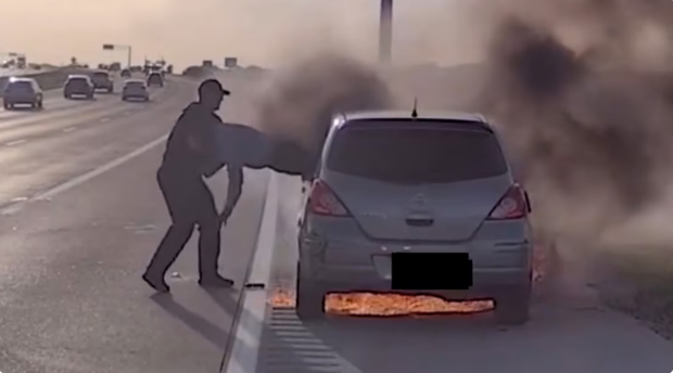 Momentul în care un polițist ajută un șofer să iasă pe geam, după ce mașina în care se afla a luat foc, pe o autostradă din Texas