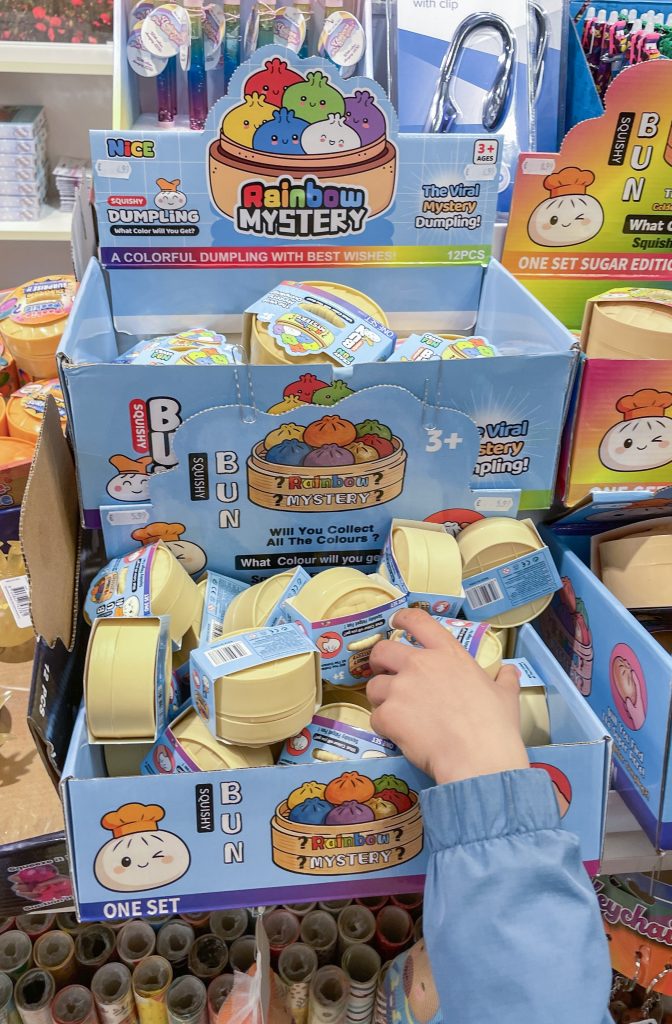 Jucărie surpriză luată de o mână de copil de la coloratul raft Rainbow Mystery și Bun Squishy, din magazinul de jucării, Genk, Belgia, 6 mai 2026